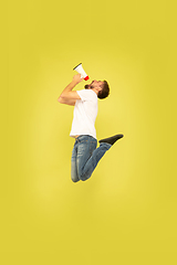 Image showing Full length portrait of happy jumping man on yellow background