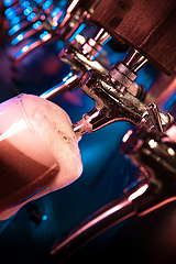 Image showing Bartender pouring a large lager beer in tap