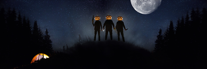 Image showing Halloween theme: scary maniacs with pumpkin head in dark forest