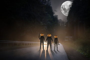 Image showing Halloween theme: scary maniacs with pumpkin head on the road