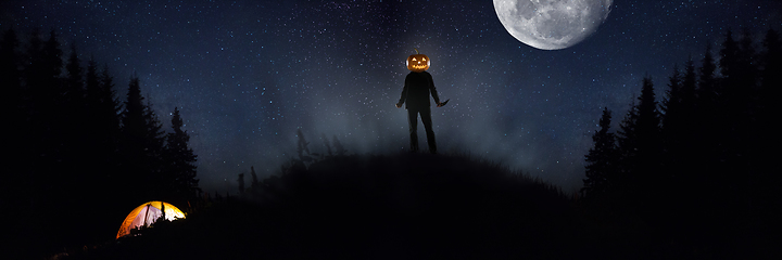 Image showing Halloween theme: scary maniac with pumpkin head in dark forest