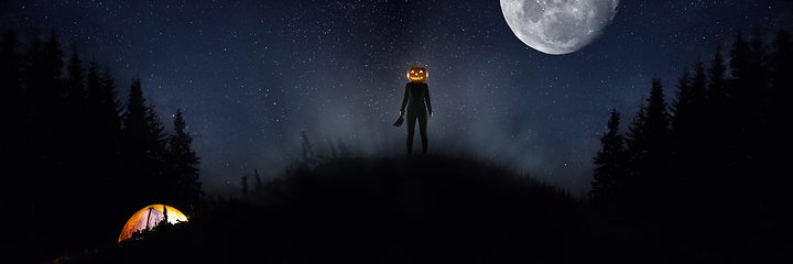Image showing Halloween theme: scary maniac with pumpkin head in dark forest