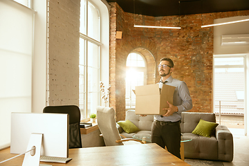 Image showing A young businessman moving in office, getting new work place