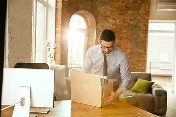 Image showing A young businessman moving in office, getting new work place