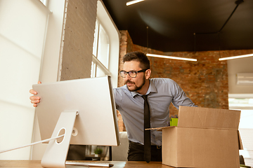 Image showing A young businessman moving in office, getting new work place