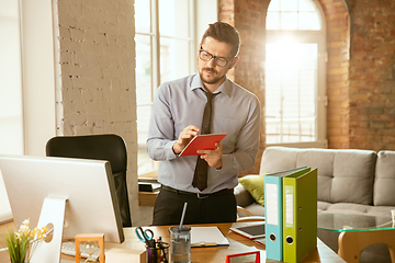 Image showing A young businessman moving in office, getting new work place