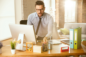 Image showing A young businessman moving in office, getting new work place