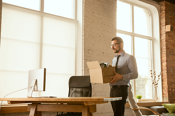 Image showing A young businessman moving in office, getting new work place