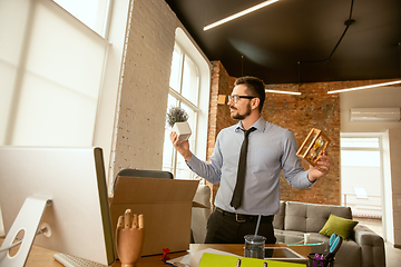 Image showing A young businessman moving in office, getting new work place