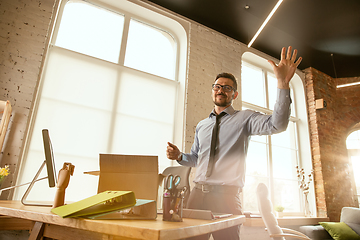 Image showing A young businessman moving in office, getting new work place