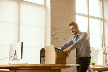 Image showing A young businessman moving in office, getting new work place