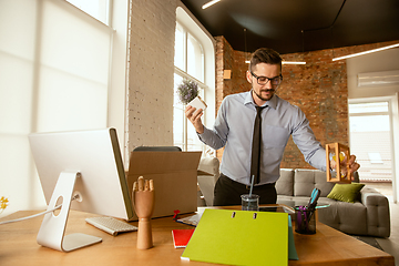 Image showing A young businessman moving in office, getting new work place