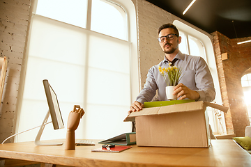 Image showing A young businessman moving in office, getting new work place