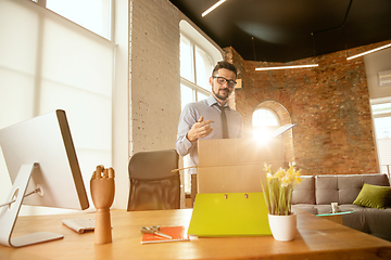 Image showing A young businessman moving in office, getting new work place