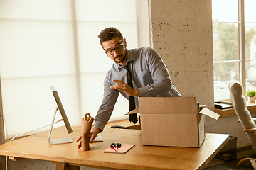 Image showing A young businessman moving in office, getting new work place