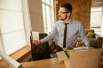 Image showing A young businessman moving in office, getting new work place