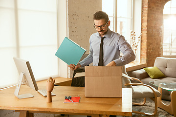 Image showing A young businessman moving in office, getting new work place