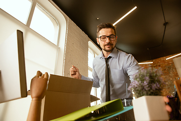 Image showing A young businessman moving in office, getting new work place