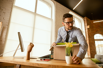 Image showing A young businessman moving in office, getting new work place