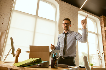 Image showing A young businessman moving in office, getting new work place