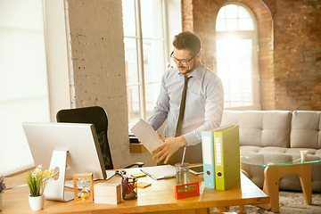 Image showing A young businessman moving in office, getting new work place