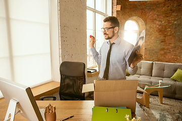 Image showing A young businessman moving in office, getting new work place