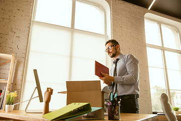 Image showing A young businessman moving in office, getting new work place