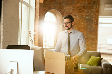 Image showing A young businessman moving in office, getting new work place