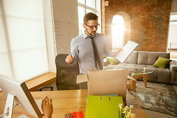 Image showing A young businessman moving in office, getting new work place