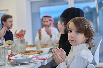 Image showing Muslim family making iftar dua to break fasting during Ramadan.