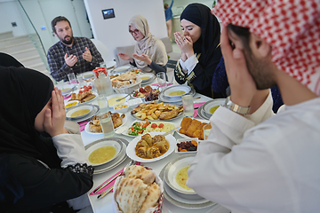 Image showing Muslim family making iftar dua to break fasting during Ramadan.