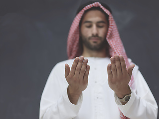 Image showing Arab man in traditional clothes praying to God or making dua