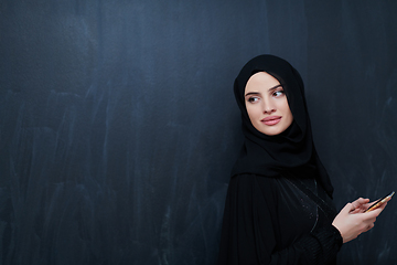 Image showing Young muslim businesswoman in traditional clothes or abaya using smartphone