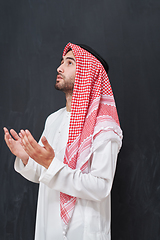 Image showing Arab man in traditional clothes praying to God or making dua