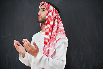 Image showing Arab man in traditional clothes praying to God or making dua