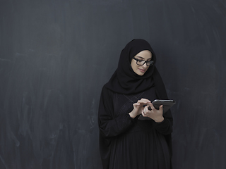 Image showing Young Arab businesswoman in traditional clothes or abaya with tablet computer