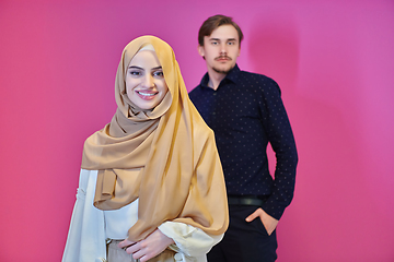 Image showing Portrait of happy young muslim couple standing isolated on pink background