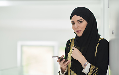 Image showing Portrait of Arab woman in traditional clothes using mobile phone