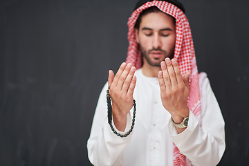 Image showing Arab man in traditional clothes praying to God or making dua