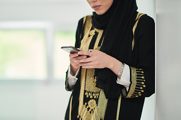 Image showing Portrait of Arab woman in traditional clothes using mobile phone