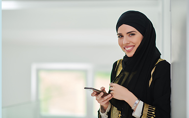 Image showing Portrait of Arab woman in traditional clothes using mobile phone