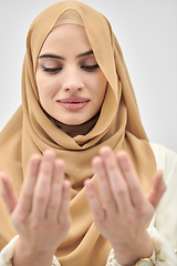 Image showing Portrait of young muslim woman making dua, praying to God