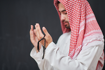 Image showing Arab man in traditional clothes praying to God or making dua