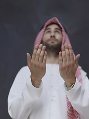 Image showing Arab man in traditional clothes praying to God or making dua