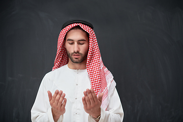 Image showing Arab man in traditional clothes praying to God or making dua