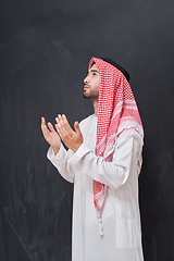 Image showing Arab man in traditional clothes praying to God or making dua