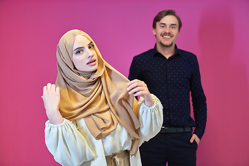 Image showing Portrait of happy young muslim couple standing isolated on pink background