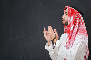 Image showing Arab man in traditional clothes praying to God or making dua