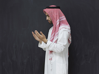 Image showing Arab man in traditional clothes praying to God or making dua