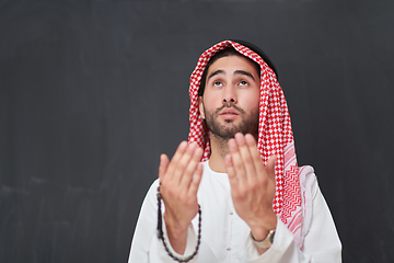 Image showing Arab man in traditional clothes praying to God or making dua